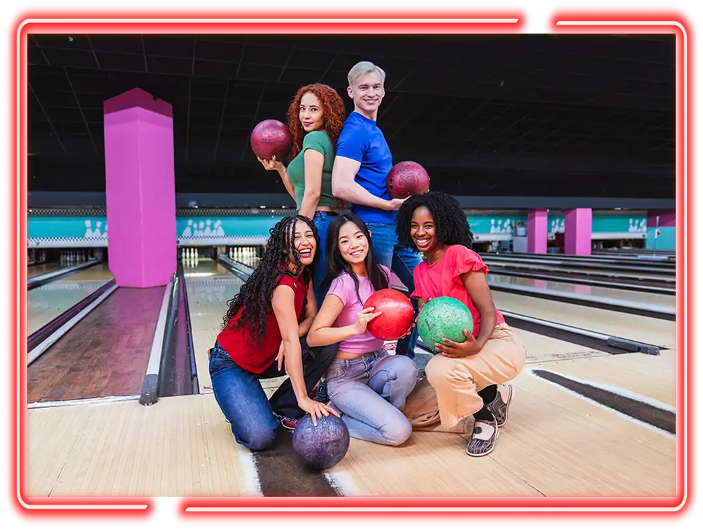 Group of six friends posing with bowling balls on the lanes at Jax 60 in Jackson, Michigan