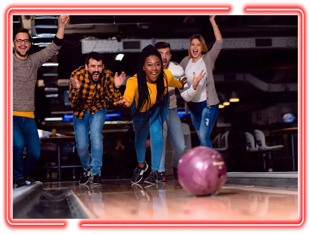 Friends cheering as a bowling ball rolls down the lane at Jax 60 in Jackson, Michigan