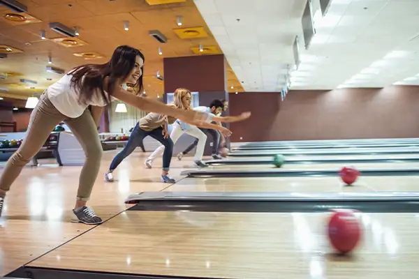 Teenagers bowling and releasing the ball down the lane at Jax 60 in Jackson, Michigan, Unlimited Teen Party Package