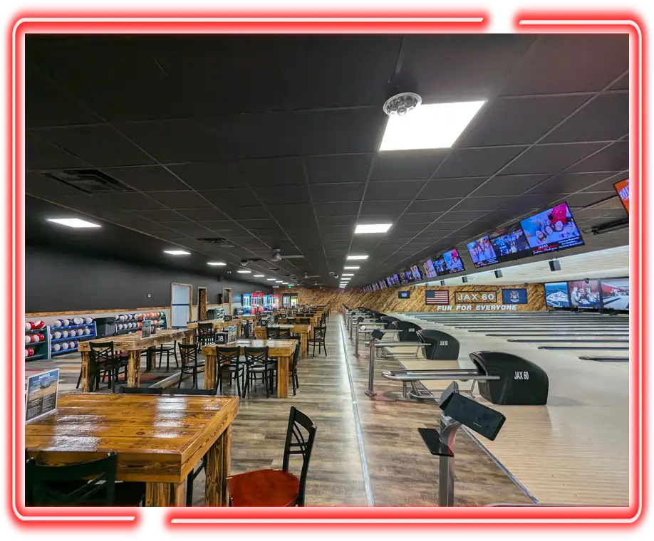 Wooden dining tables and bowling lanes beneath the Jax 60 sign in Jackson, Michigan