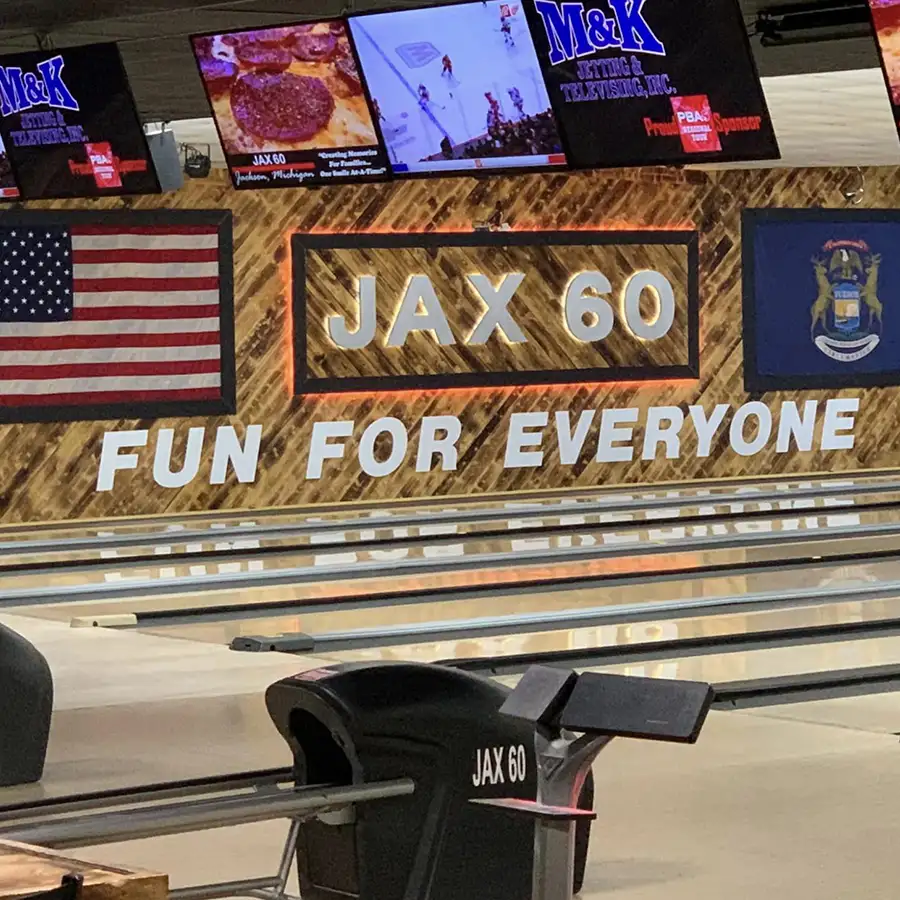Jax 60 wood-paneled sign and TV screens above the lanes in Jackson, Michigan