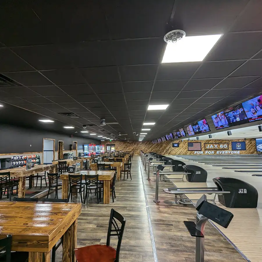 Wooden dining tables and bowling lanes with TV screens at Jax 60 in Jackson, Michigan