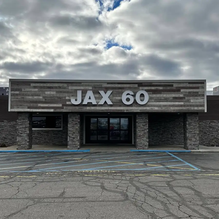 Exterior storefront of Jax 60 under a cloudy sky in Jackson, Michigan