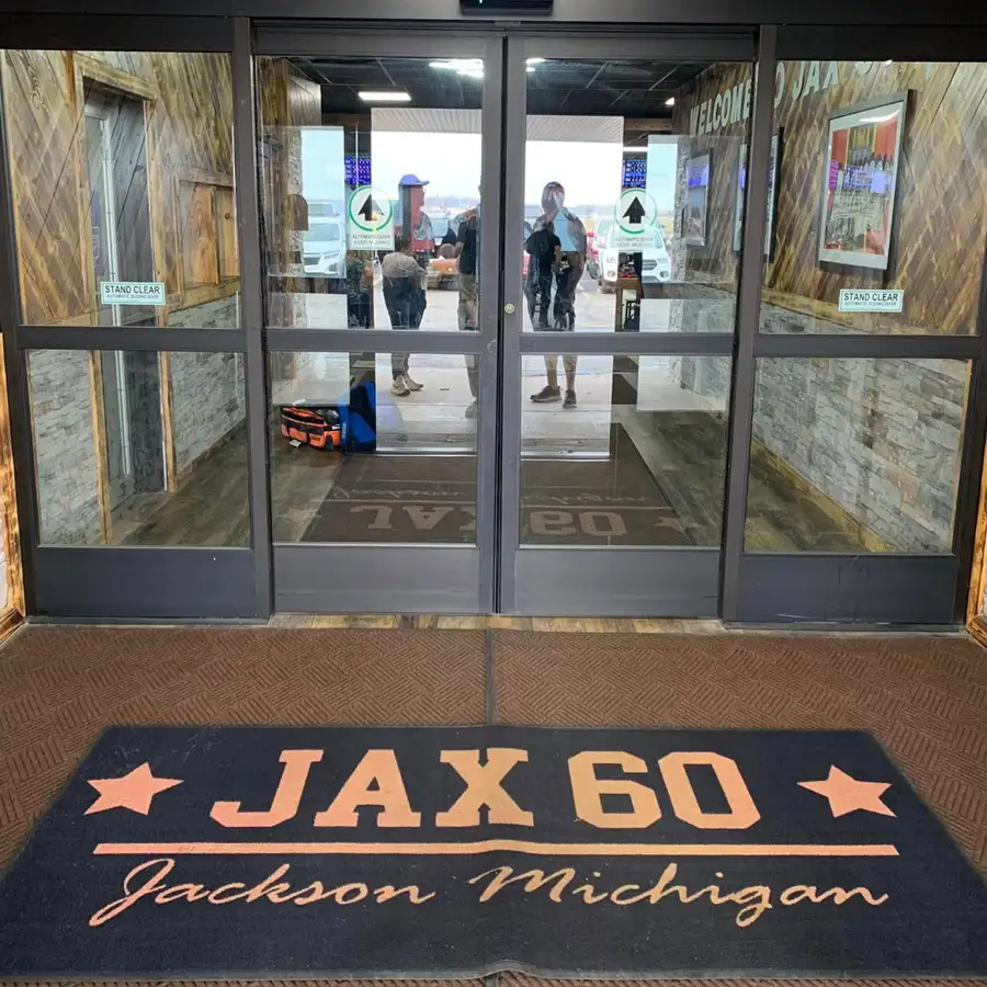 Front entrance doors and welcome mat at Jax 60 in Jackson, Michigan