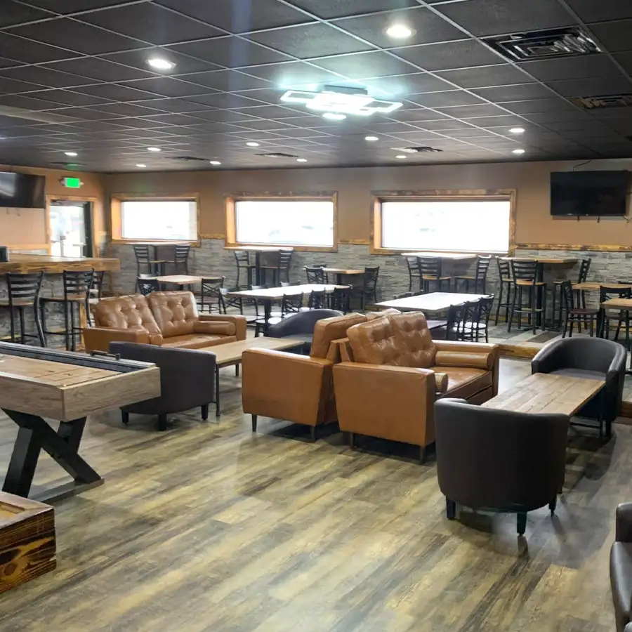 Lounge seating area with leather couches and high-top tables at Jax 60 in Jackson, Michigan