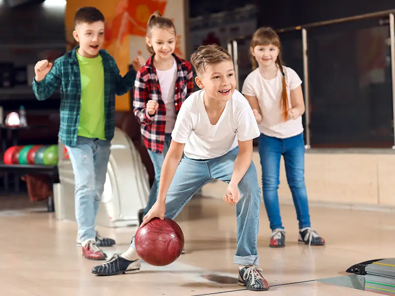 Kids cheering and bowling together at a birthday party at Jax 60 in Jackson, Michigan